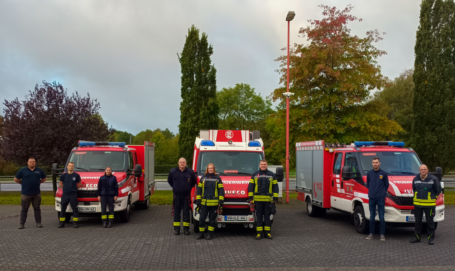 Feuerwehr-Einsatzfahrzeuge mit den Ausbildern und erfolgreichen Absolventen