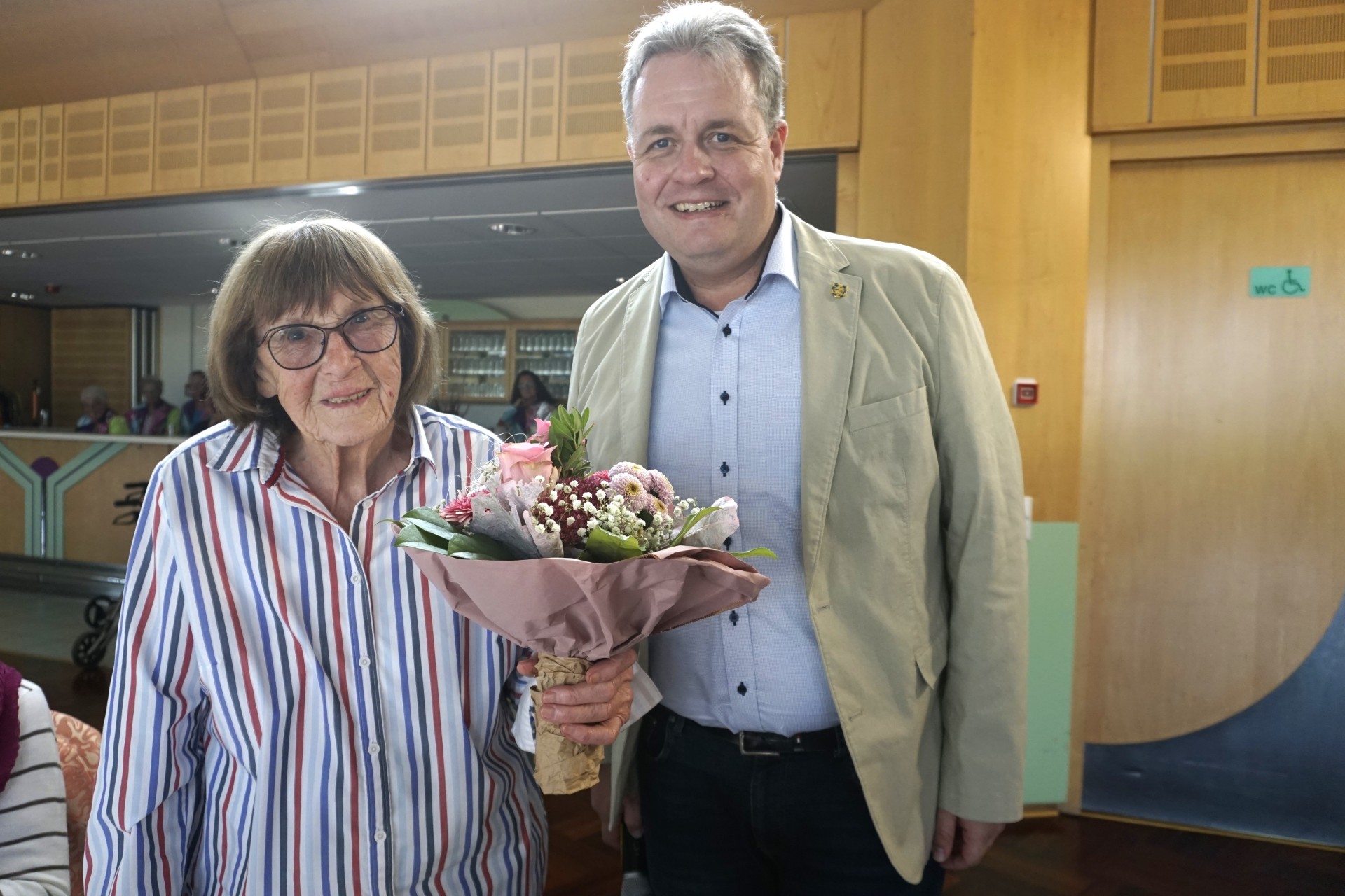 Die älteste Teilnehmerin Frau Agathe Hering (98) erhält einen Blumenstrauß von Bürgermeister Gerrit Müller.
